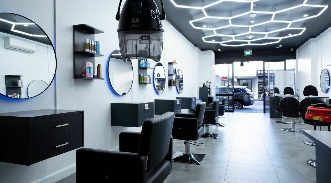 Modern interior of 3 Points Hair Extensions and Barbering in Melbourne, Victoria, AU, featuring sleek black chairs.