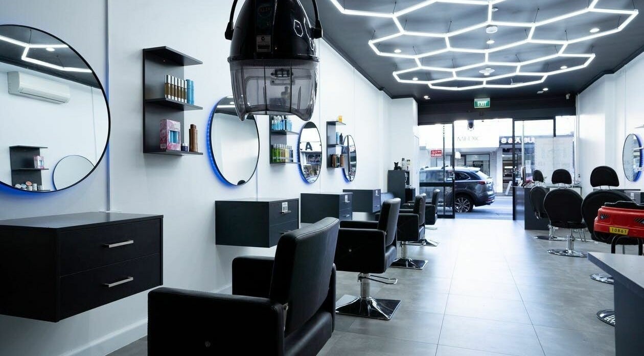 Modern interior of 3 Points Hair Extensions and Barbering in Melbourne, Victoria, AU, featuring sleek black chairs.