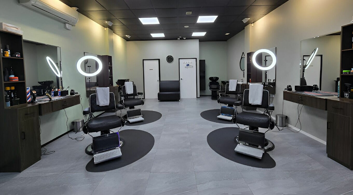 Interior of Gentlemen's Barbers Auckland Airport, featuring stylish chairs and modern lighting in Auckland, NZ.