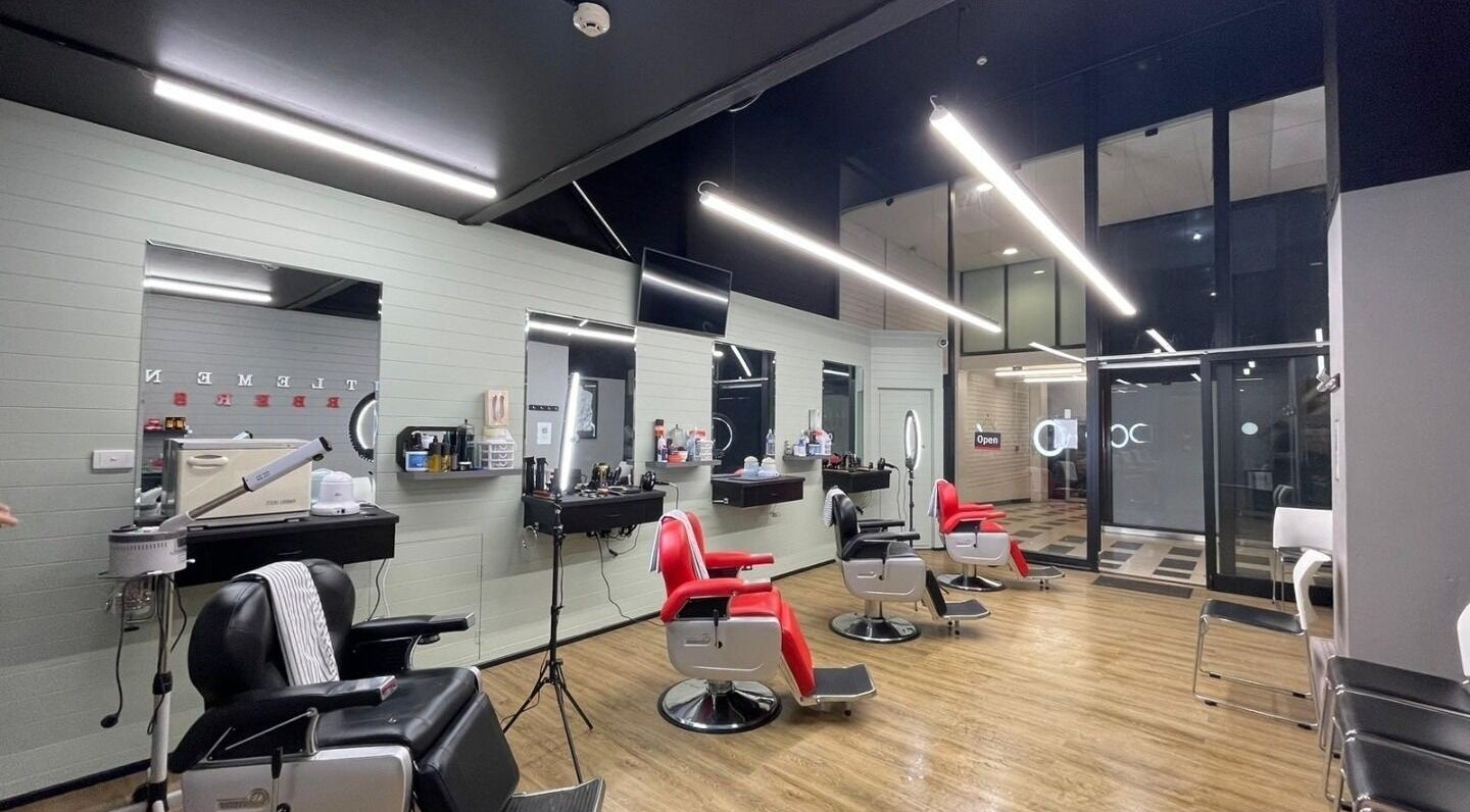 Modern interior of Gentlemen's Barbers Hamilton in Waikato, NZ with stylish red and black barber chairs.