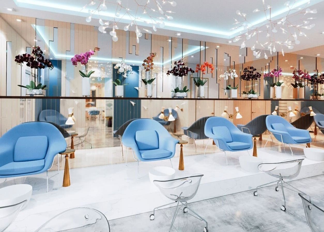 Modern lounge with blue chairs at Cloud Eleven Beauty Salon, Dubai, Dubai, AE, showcasing orchids and sleek decor.