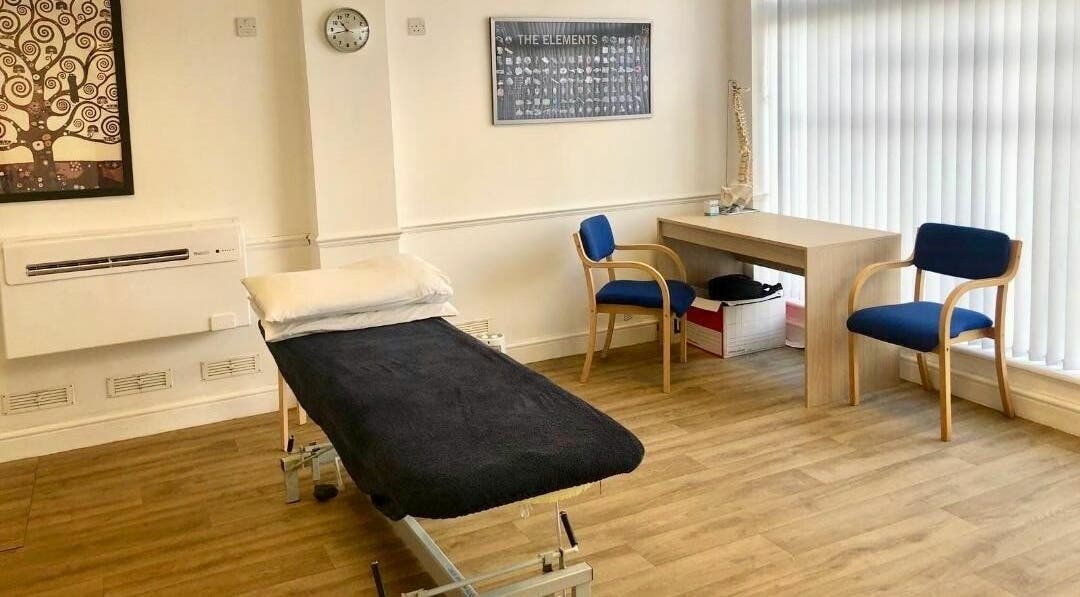 A calm, well-lit treatment room at Wallington Osteopaths in Carshalton Beeches, England, GB with a treatment bed.