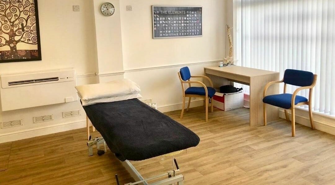 A calm, well-lit treatment room at Wallington Osteopaths in Carshalton Beeches, England, GB with a treatment bed.