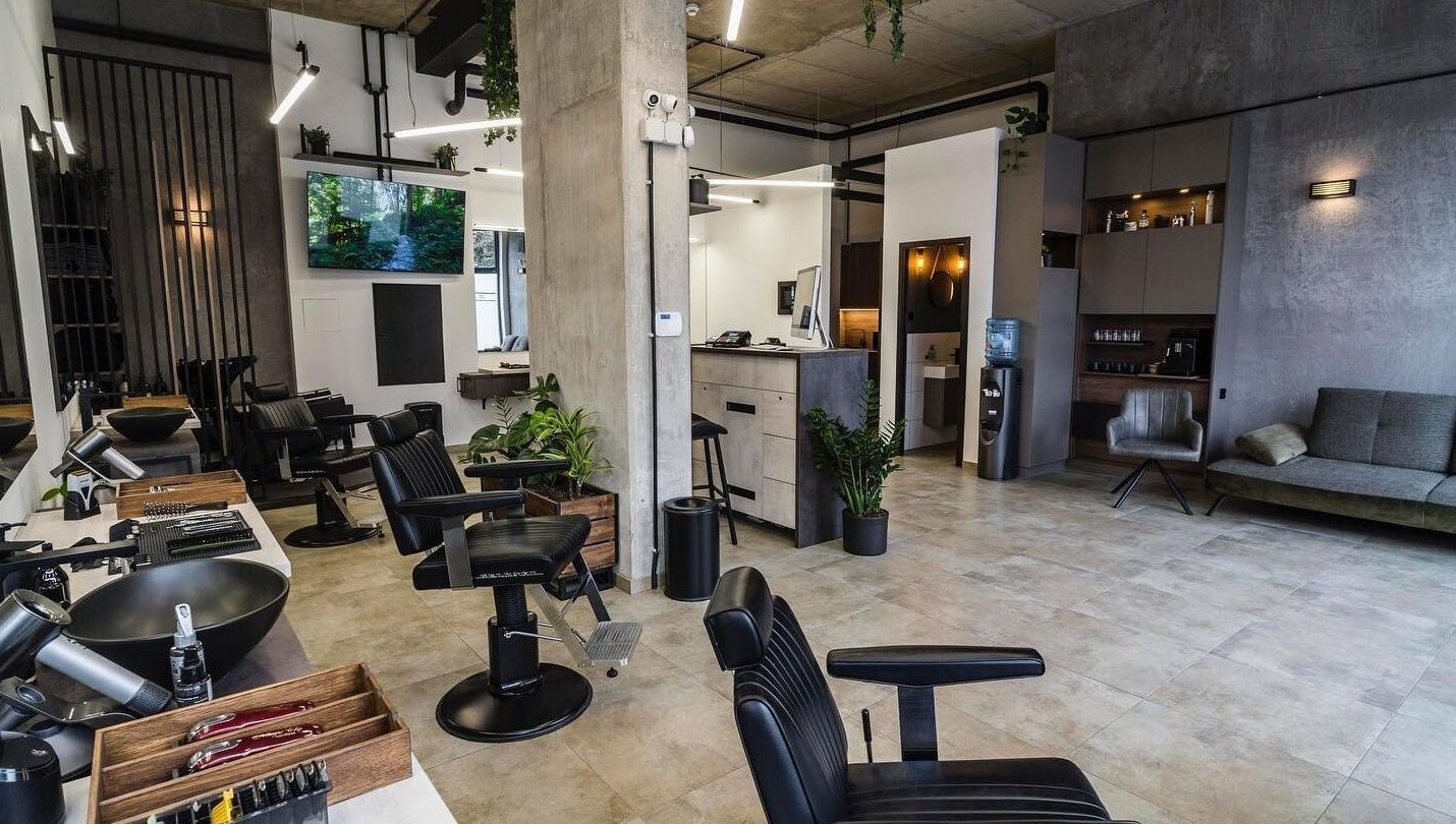 Modern salon interior at Initials, featuring sleek black chairs and greenery, Budapest, Magyar, HU.