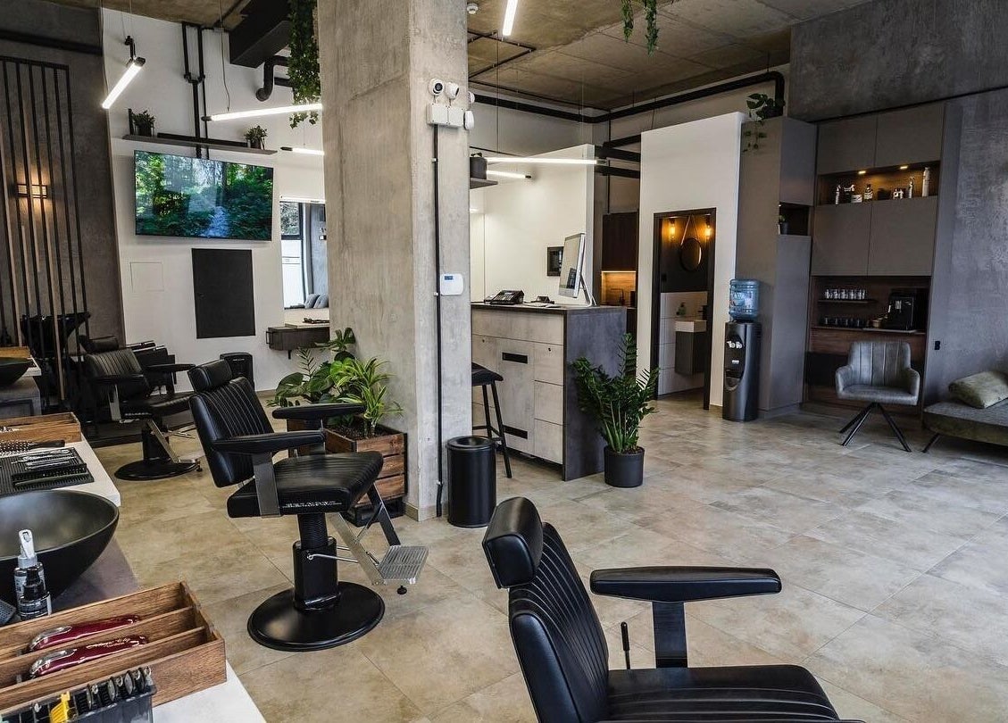 Modern salon interior at Initials, featuring sleek black chairs and greenery, Budapest, Magyar, HU.