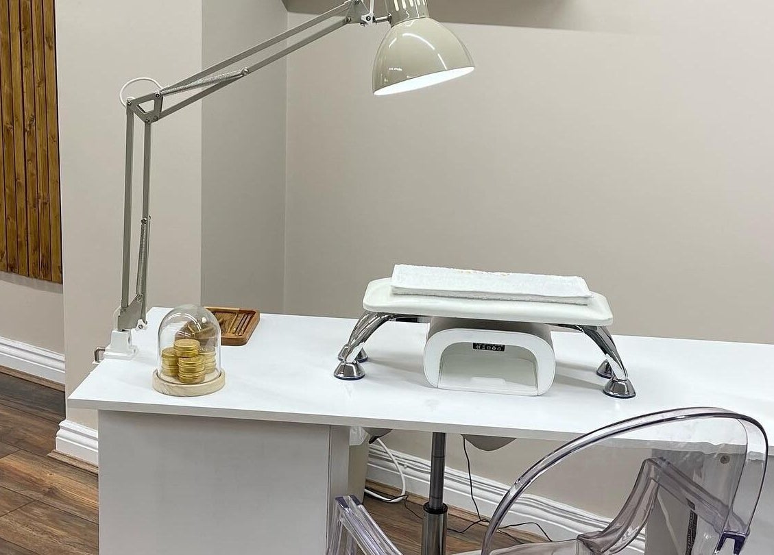 Elegant nail station at Repose Beauty and Wellbeing, Macclesfield, England, GB, featuring a lamp and modern chair.