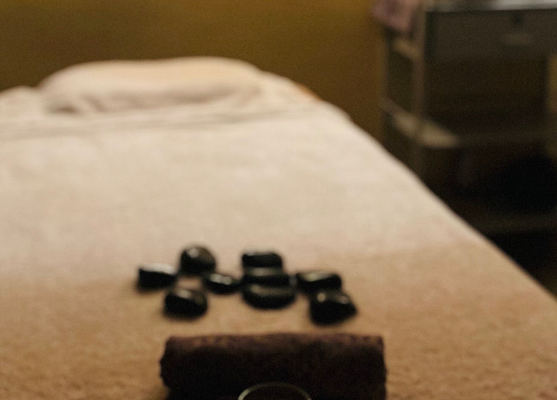 Relaxing massage table setup at Aora Spa and Wellness - Lumut, showcasing stones in Lumut, Perak, MY.