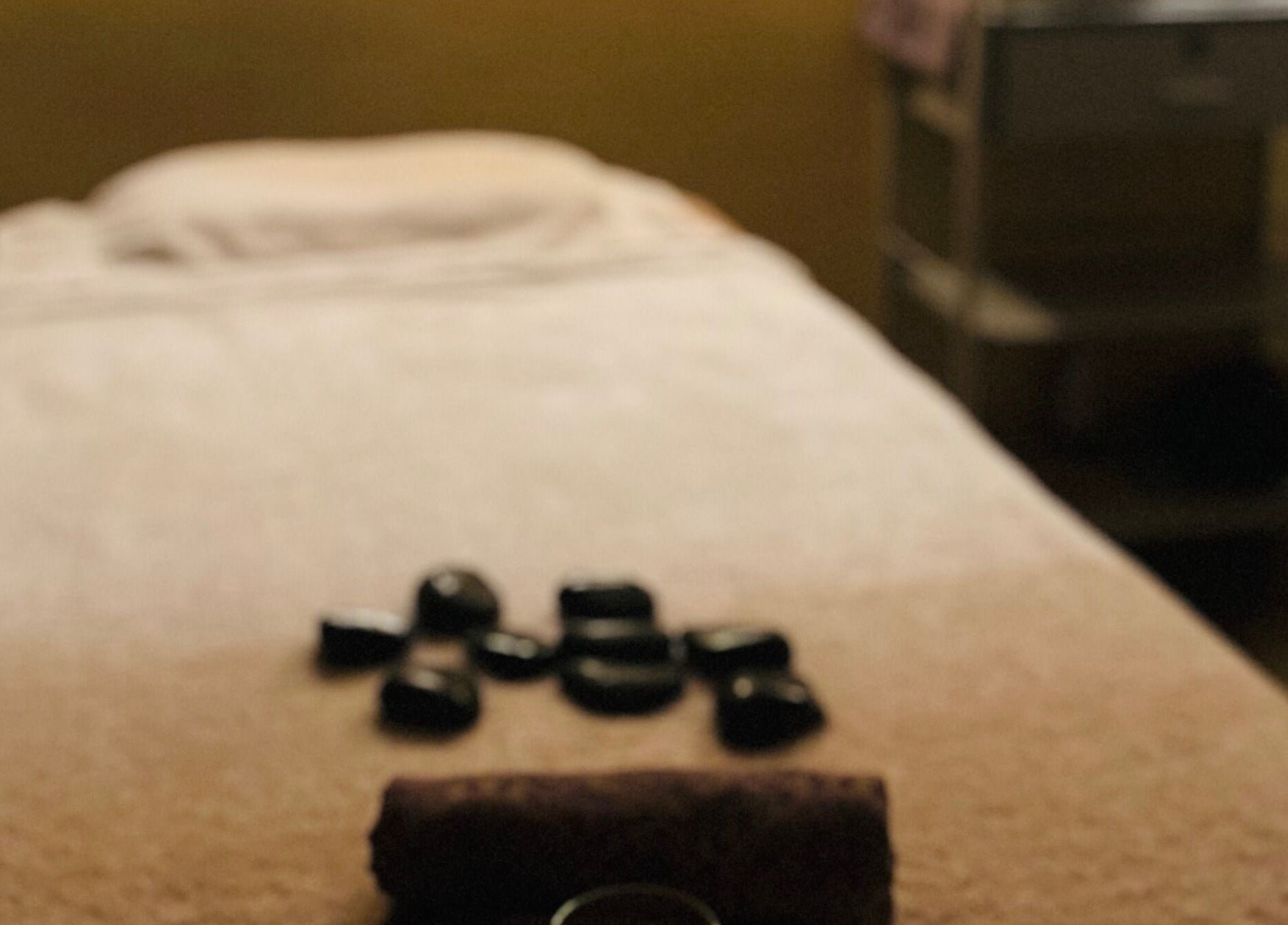 Relaxing massage table setup at Aora Spa and Wellness - Lumut, showcasing stones in Lumut, Perak, MY.