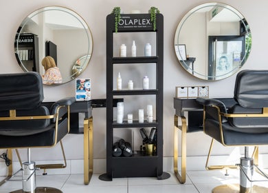 Stylish salon interior at Salon No. 100, Bentley Heath, England, GB with chic mirrors and luxurious chairs.