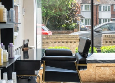 Modern styling chair and products at Salon No. 100, Bentley Heath, England, GB, with window view.