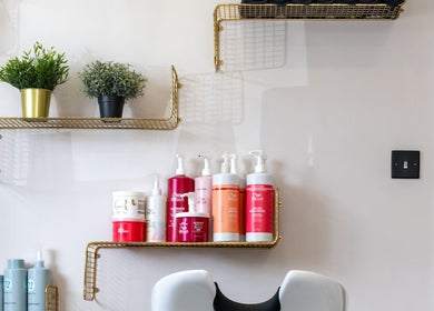 Salon No. 100's product display with vibrant bottles on stylish shelves in Bentley Heath, England, GB.