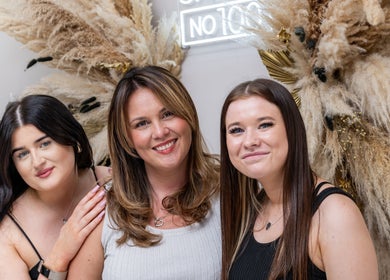 Friendly staff at Salon No. 100 in Bentley Heath, England, GB, smiling with stylish decor behind them.
