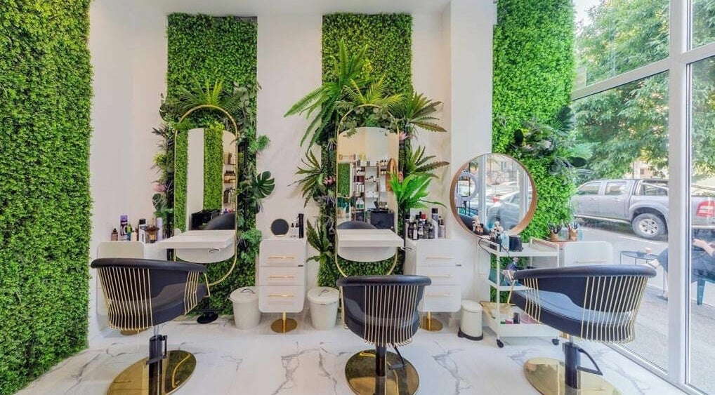 Scaune elegante și oglinzi stilate la 4AM Beauty and Shop, București, București, RO, înconjurate de verdeață luxuriantă.