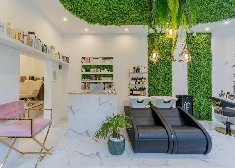 Interior spațios la 4AM Beauty and Shop, București, decorat modern cu plante verzi și scaune confortabile.