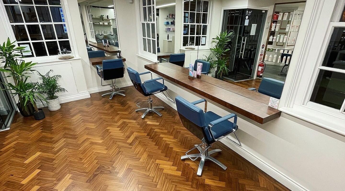 Chic salon interior at Tonics, Horsham, England, GB showcasing sleek design with modern chairs and mirrors.