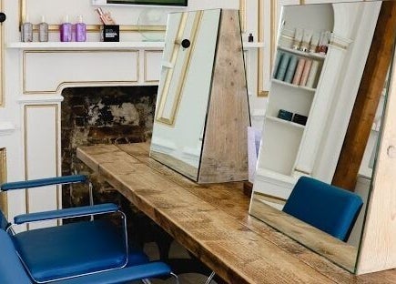 Sophisticated salon interior at Tonics, featuring chic mirrors and elegant decor in Horsham, England, GB.