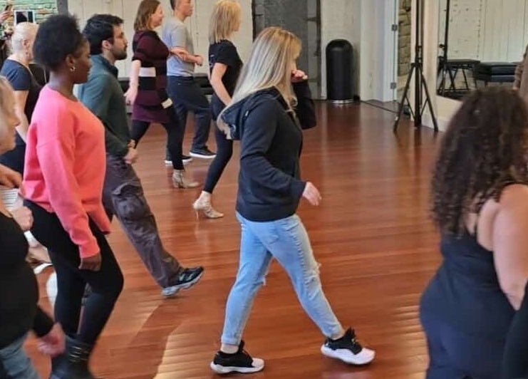 Group dance class at PIVOT Dance Emporium, Seattle, Washington, US in full swing on elegant wooden floors.