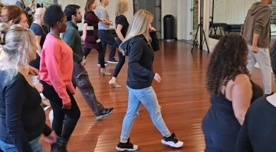 Group dance class at PIVOT Dance Emporium, Seattle, Washington, US in full swing on elegant wooden floors.