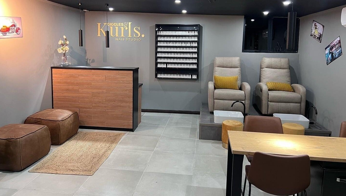 Interior of Giggles n Kurls Nail Studio Hartbeespoort, featuring cozy chairs and elegant decor in Hartbeespoort, North West, ZA.