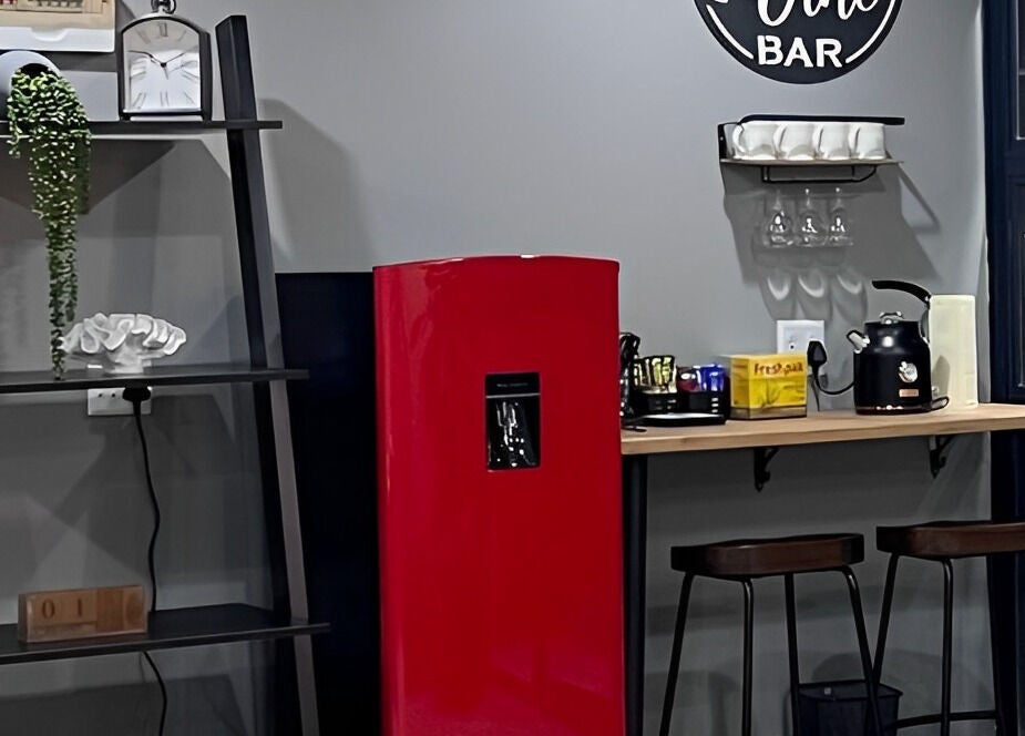 Chic beverage bar at Giggles n Kurls Nail Studio Hartbeespoort, North West, ZA with red fridge and black kettle.