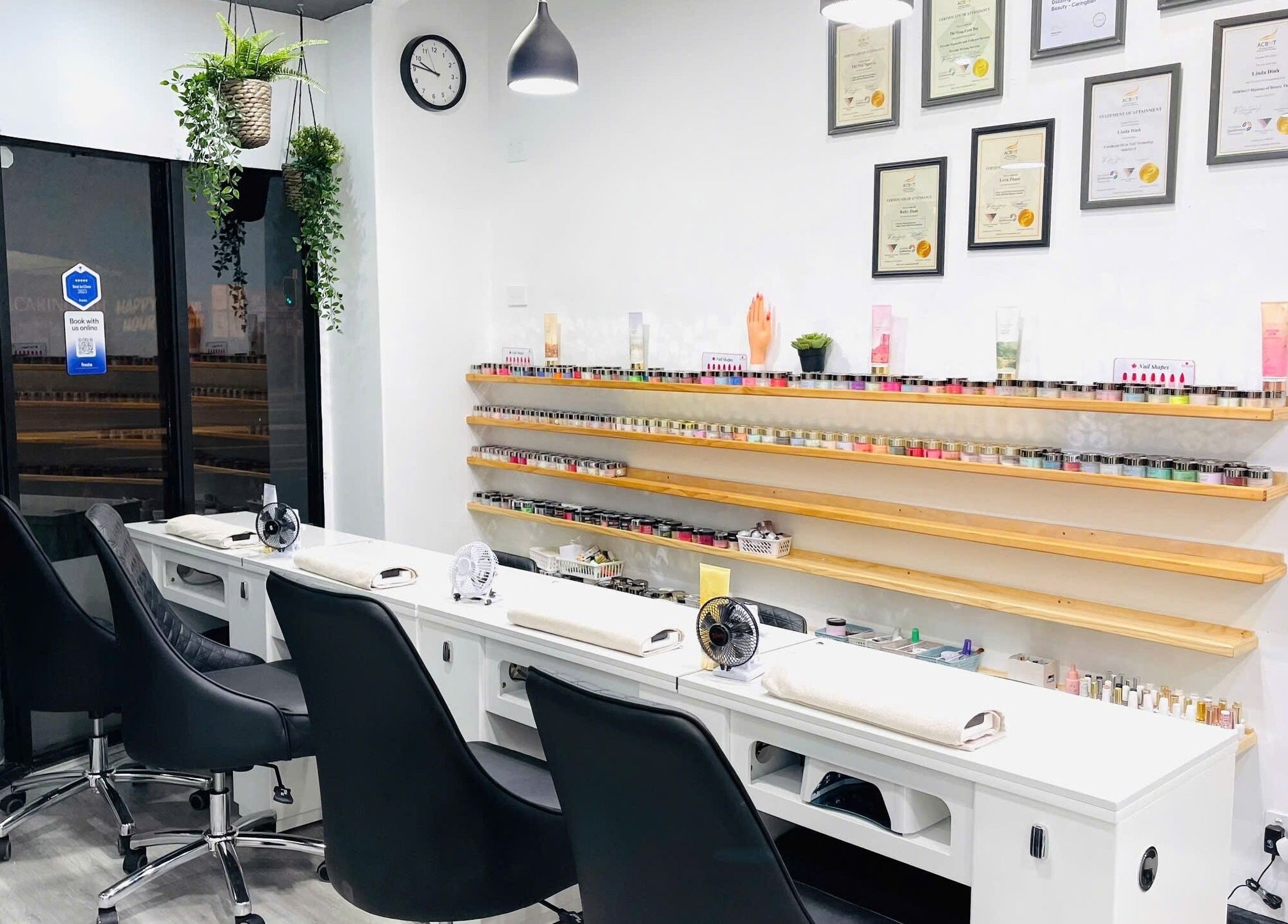 Inside Dazzling Nails and Beauty, Caringbah, New South Wales, AU. Sleek nail station with shelves lined with nail polish.