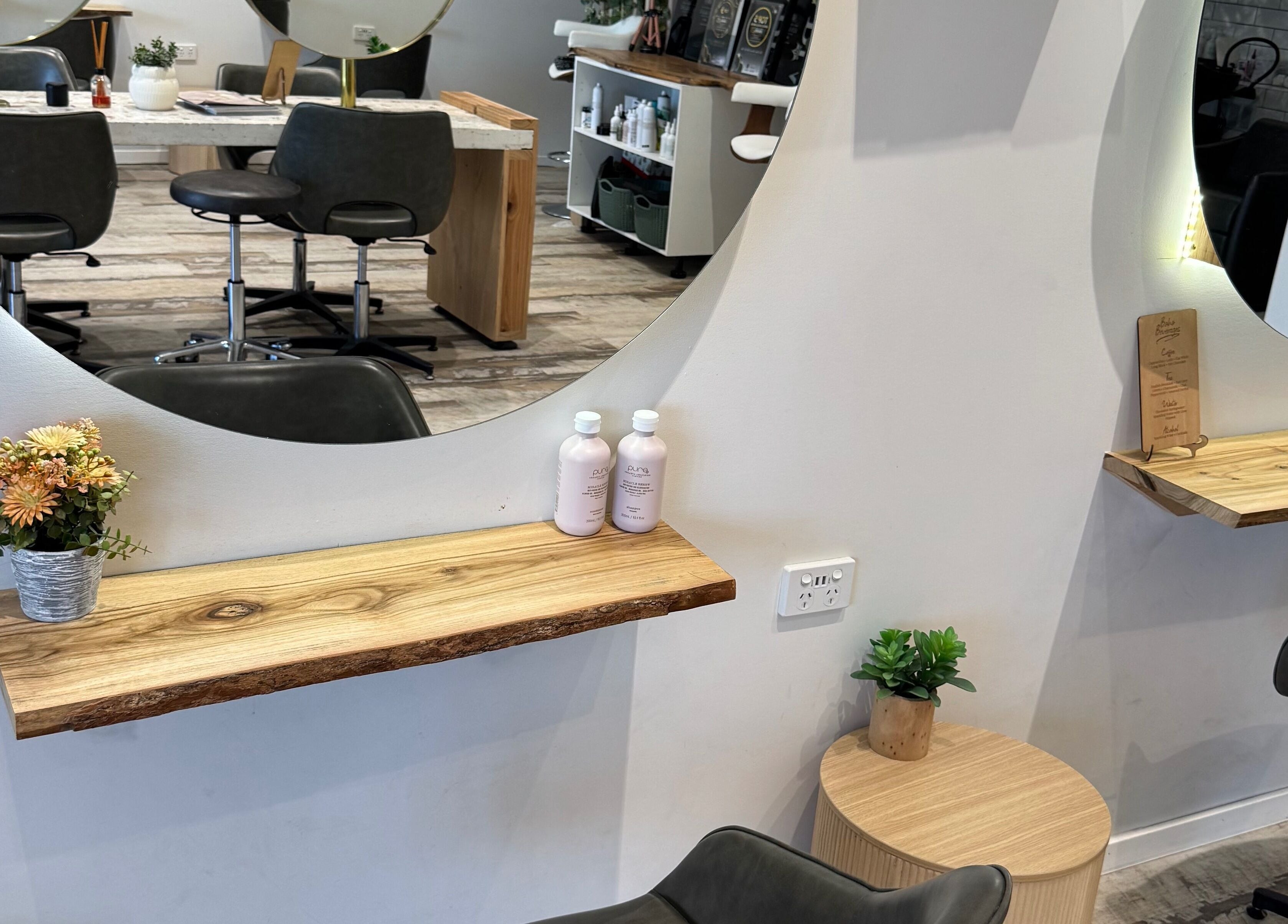 Elegant interior of Boho Boutique Hair Salon, Yarrabilba, Queensland, AU, featuring chic mirrors and sleek chairs.
