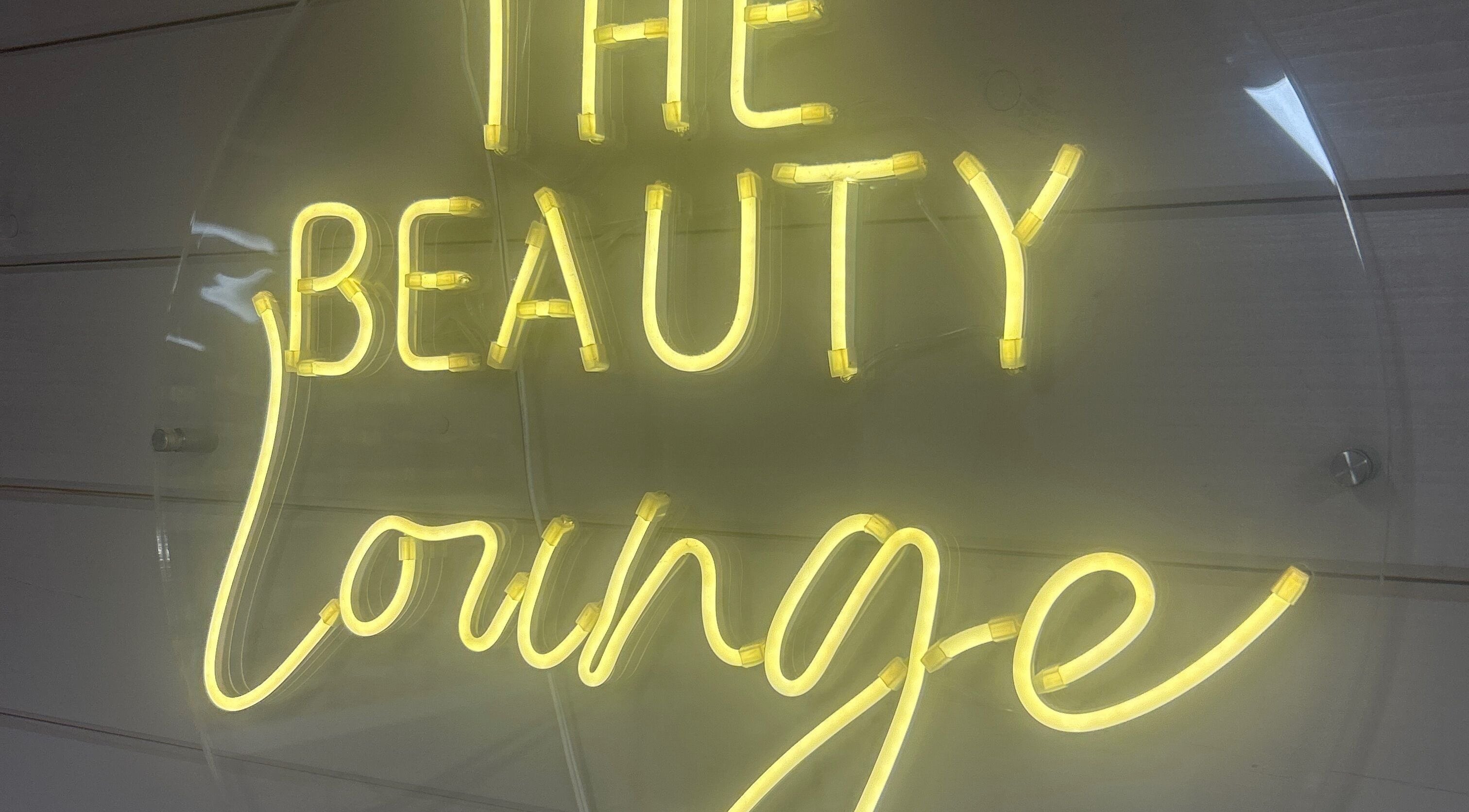 Illuminated sign of The Beauty Lounge at King's Lynn, England, GB glows warmly.