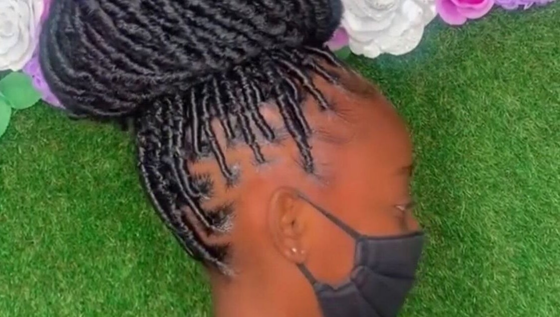 Intricate braided hairstyle at Royaltii Designs, Bridgetown, Saint Michael, BB, against a floral backdrop.