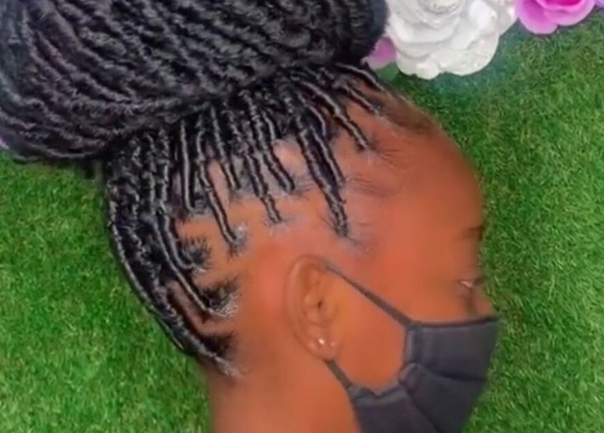 Intricate braided hairstyle at Royaltii Designs, Bridgetown, Saint Michael, BB, against a floral backdrop.