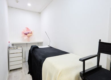 Lash Bar's tranquil treatment room in Bondi Junction, New South Wales, AU, featuring a cozy bed and elegant decor.