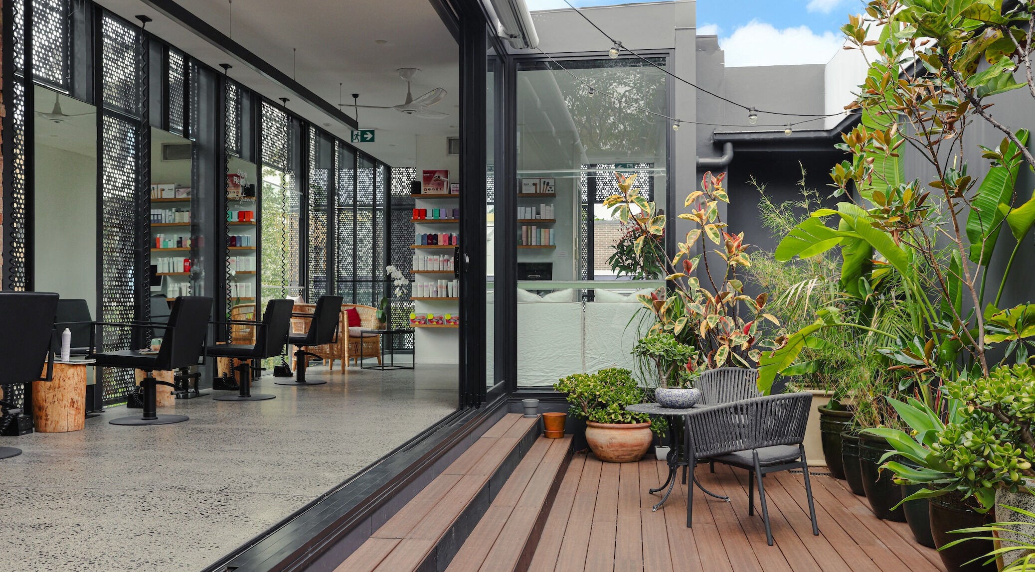 Open, lush interior of Willomina in Woollahra, New South Wales, AU, with plants and salon chairs.