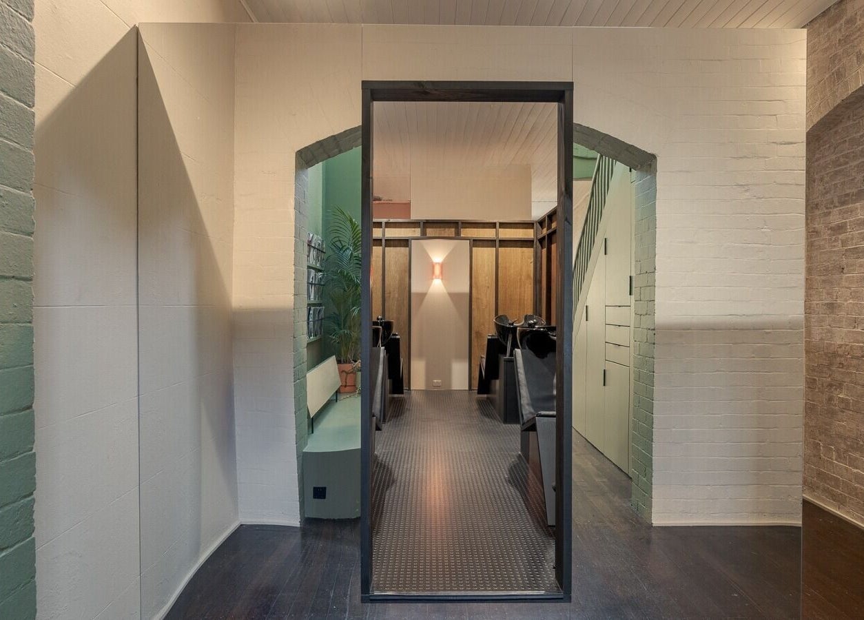 Modern salon interior at A_STUDIO, Darlinghurst, New South Wales, AU with sleek decor and warm lighting.