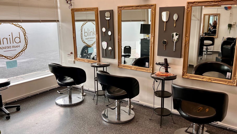 Elegant interior of Blink Hair Design in Christchurch, Canterbury, NZ with stylish chairs and framed mirrors.