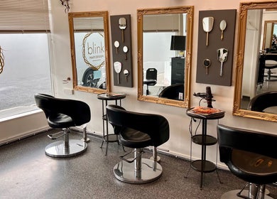 Elegant interior of Blink Hair Design in Christchurch, Canterbury, NZ with stylish chairs and framed mirrors.