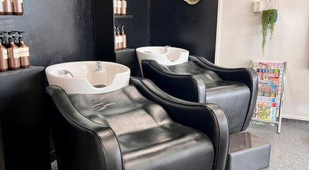 Luxurious wash stations at Blink Hair Design in Christchurch, Canterbury, NZ, featuring sleek black chairs and shampoo bottles.