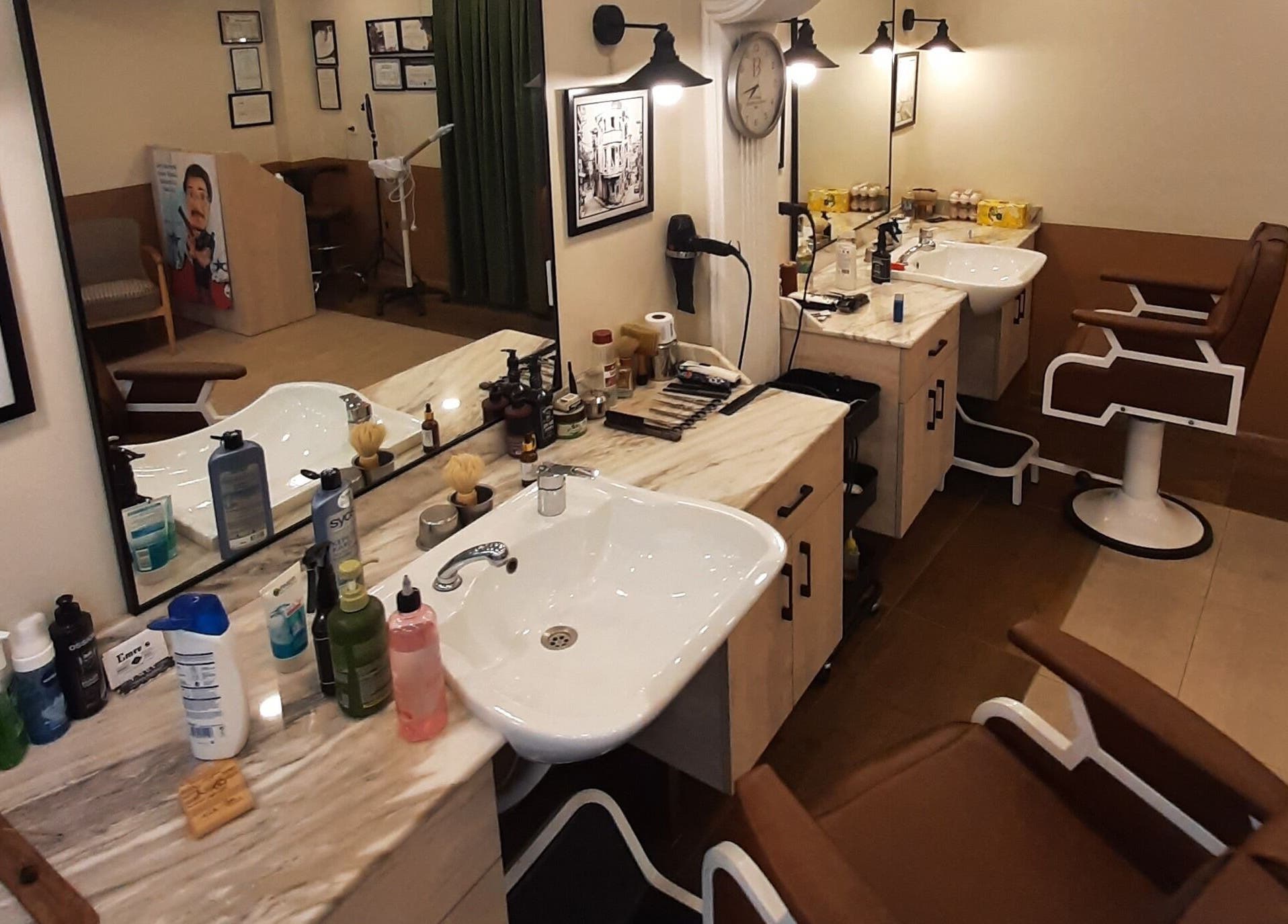 Interior of Emre's Barbershop Dolapdere in İstanbul, İstanbul, TR with stylish barber chairs and grooming products.