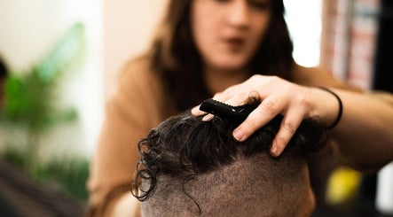 Stylist at Redcliff Refinery Barbershop & Salon in Redcliff, Alberta, CA gives a haircut.