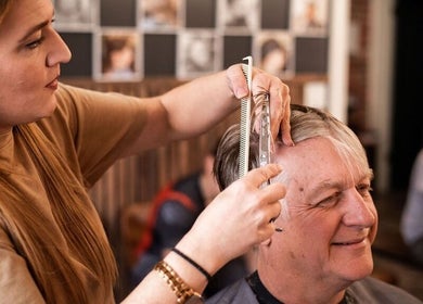 Stylist cutting hair at Redcliff Refinery Barbershop & Salon, Redcliff, Alberta, CA.