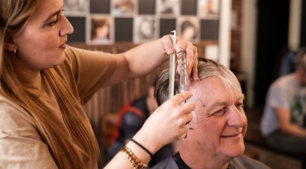 Stylist cutting hair at Redcliff Refinery Barbershop & Salon, Redcliff, Alberta, CA.