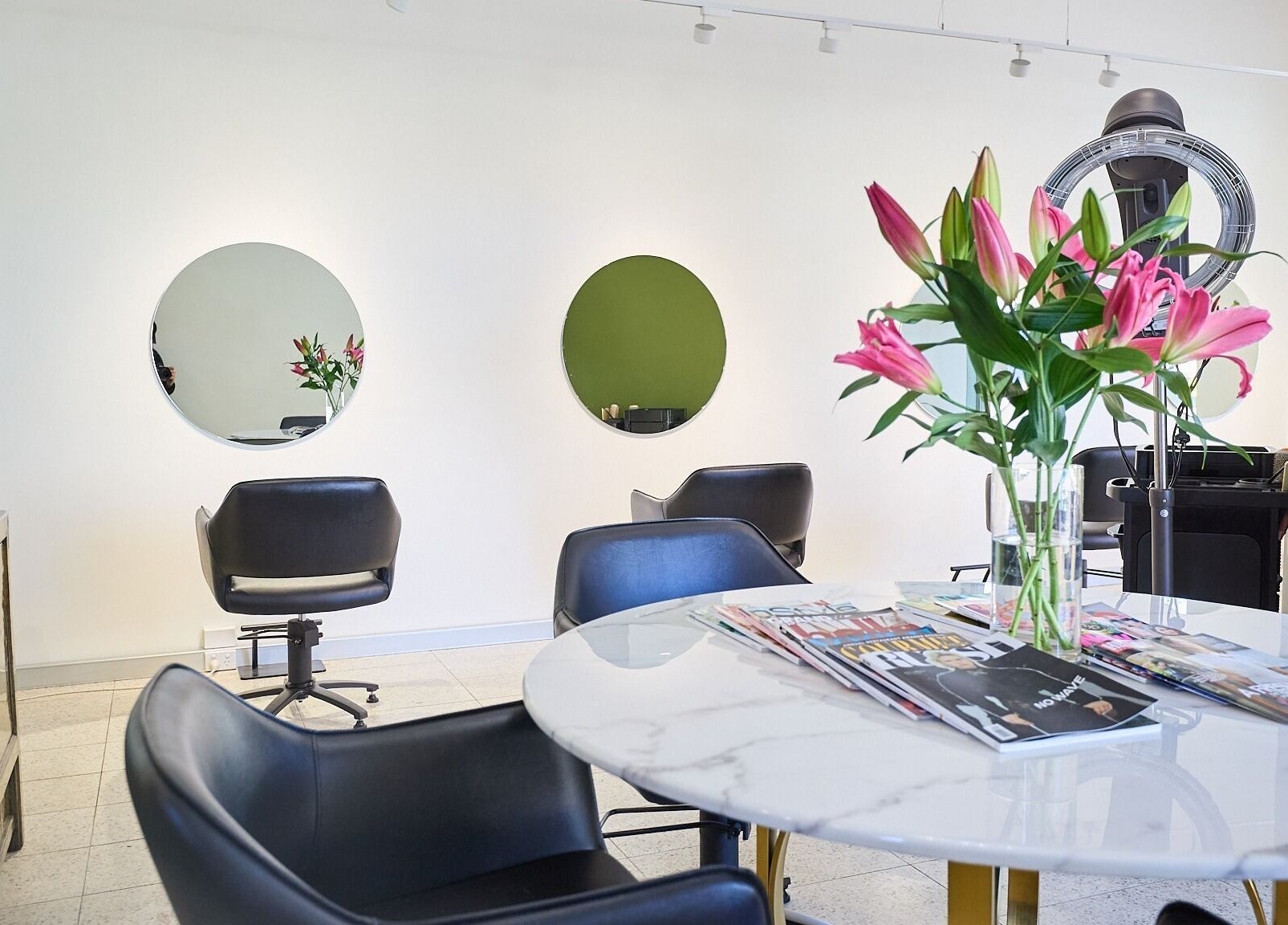 Modern salon interior at Lit & Scott in Stanmore, New South Wales, AU with stylish chairs and floral decor.
