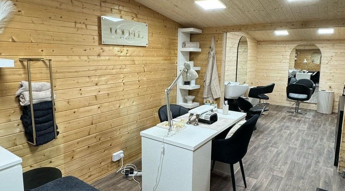 Louell Beauty salon interior with wooden decor in Bury, England, GB, showcasing manicure and styling stations.