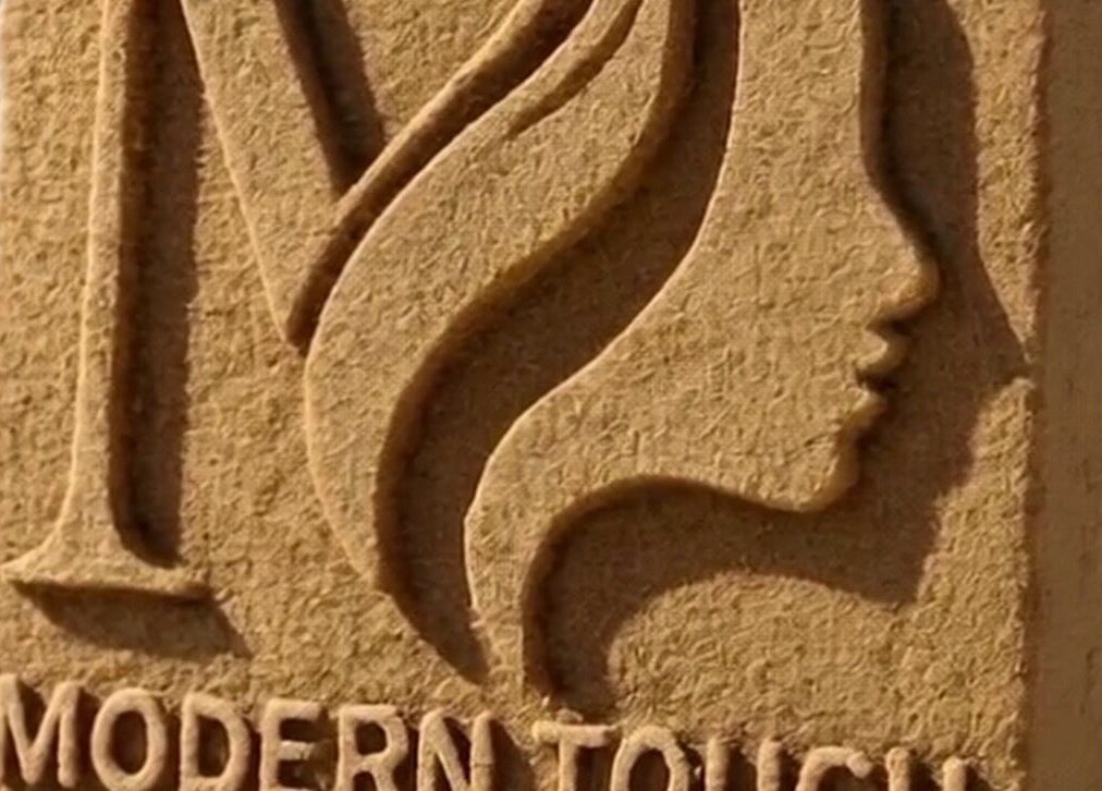 Sand sculpture of Modern Touch Hair & Beauty logo on Melbourne, Victoria, AU beach.
