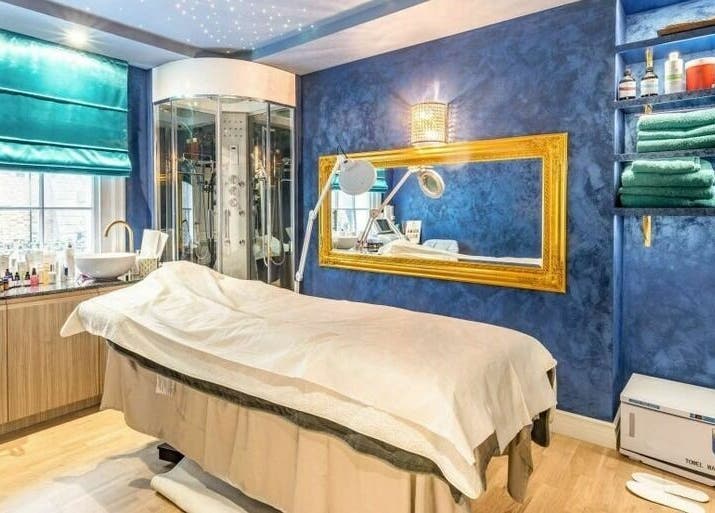 Luxurious spa room at Medusa 622, London, England, GB with blue walls, elegant decor, and treatment bed.