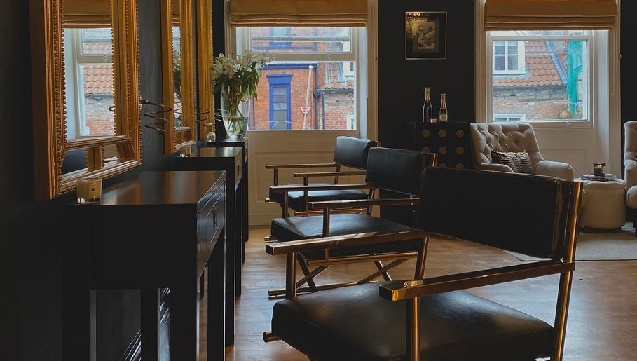 Chic interior of Regents of Beverley salon in Beverley, England, GB, featuring stylish chairs and large mirrors.