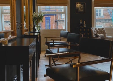 Chic interior of Regents of Beverley salon in Beverley, England, GB, featuring stylish chairs and large mirrors.