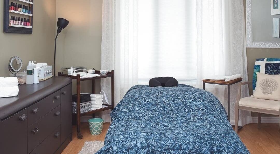 Cozy massage room at Bronzed Beauty Bar in Lucan, Ontario, CA featuring a tranquil setting with plush bedding.