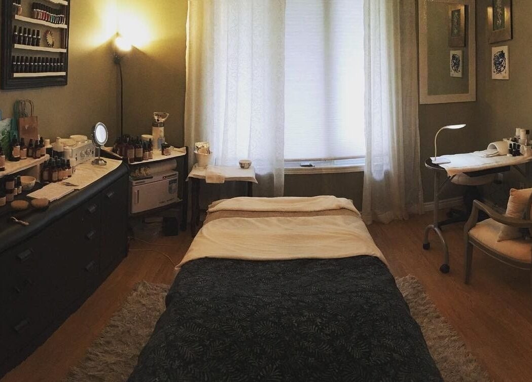 Relaxing treatment room at Bronzed Beauty Bar, Lucan, Ontario, CA, featuring a cozy bed and skincare products.