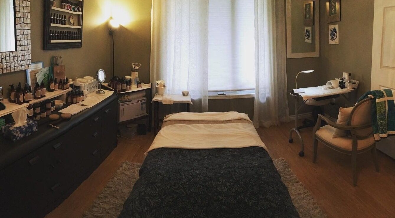Relaxing treatment room at Bronzed Beauty Bar, Lucan, Ontario, CA, featuring a cozy bed and skincare products.