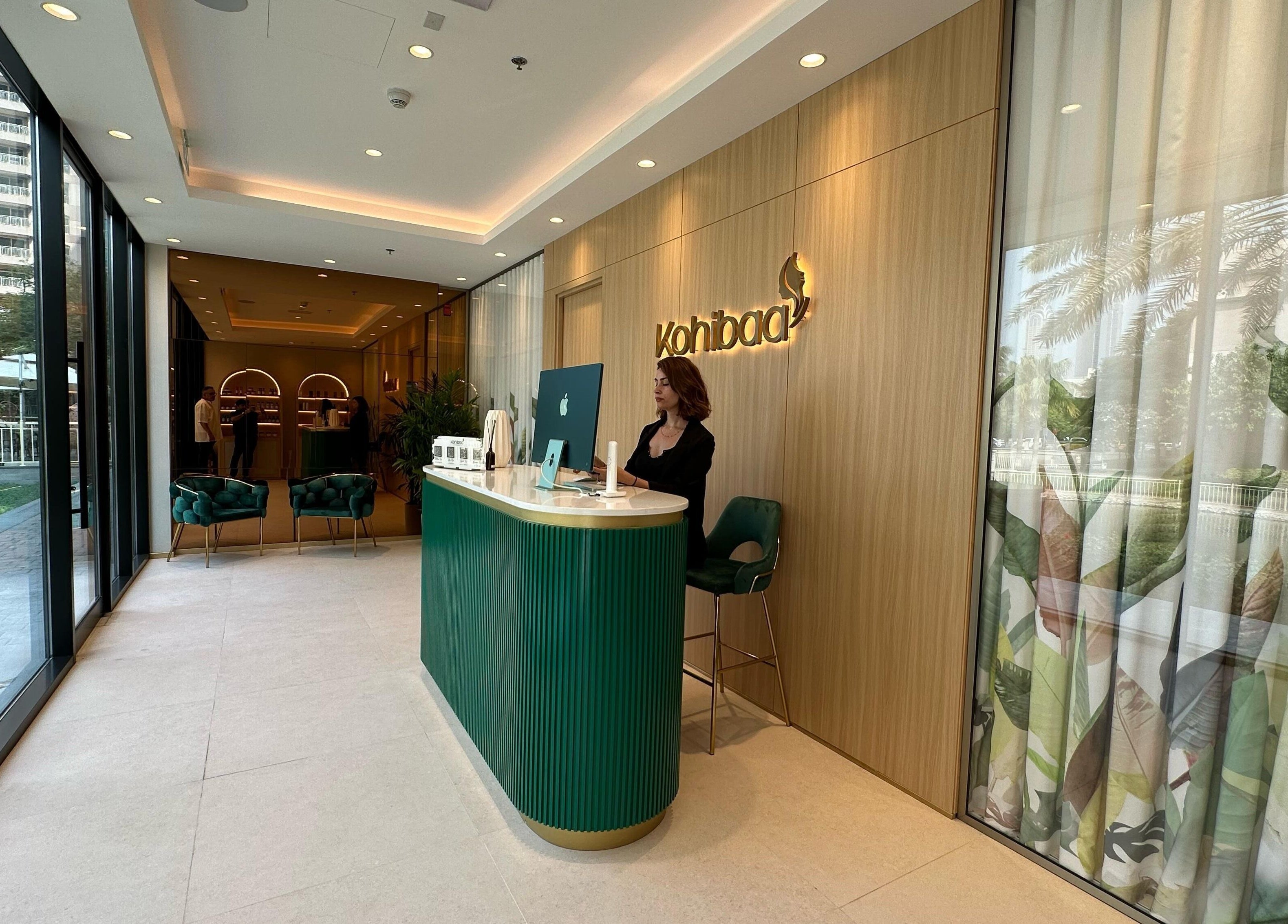 Reception area of Kohibaa Beauty Salon The Greens in Dubai, Dubai, AE with stylish decor and green chairs.