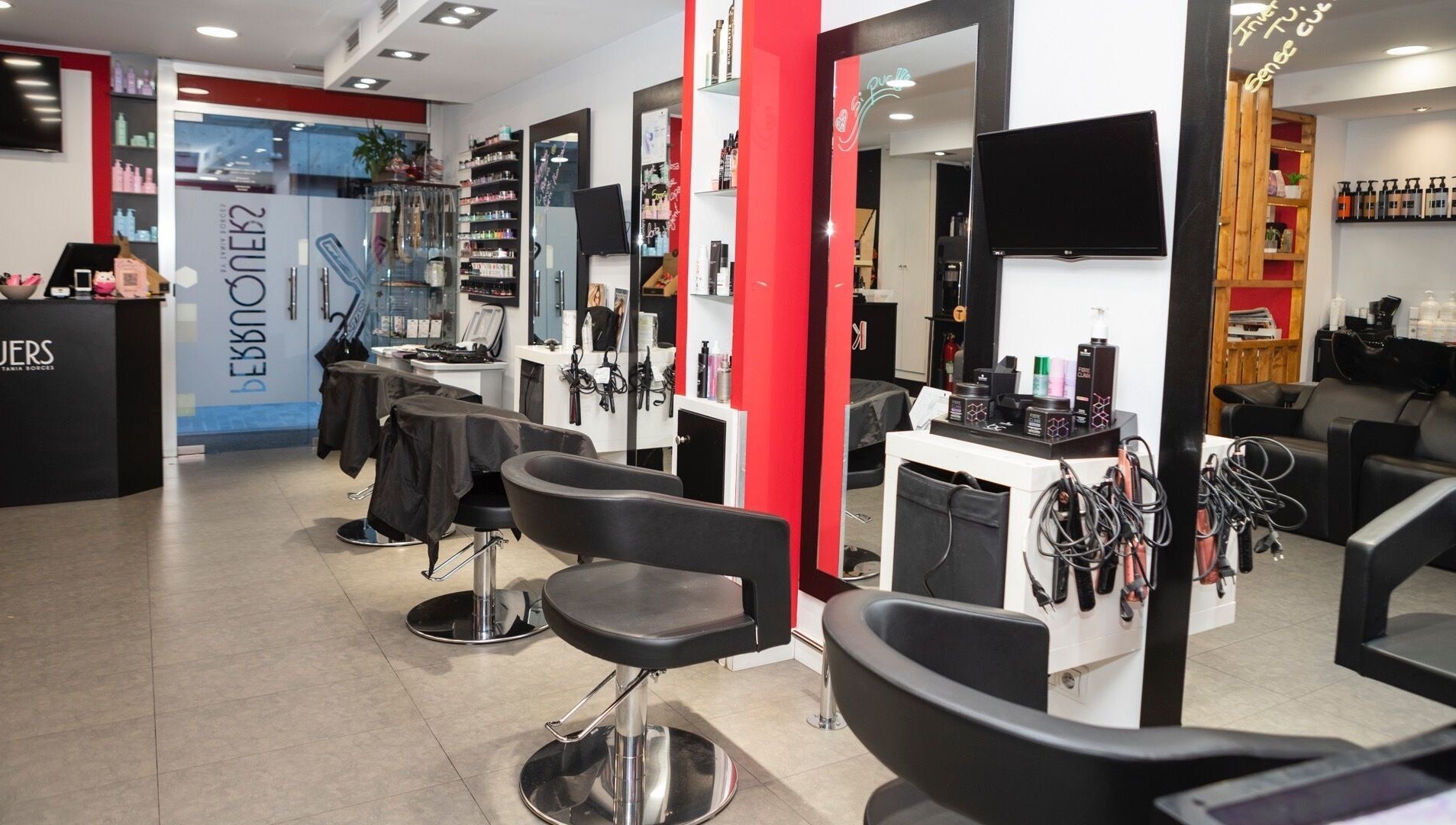 Interior moderno de K Perruquers en Andorra la Vella, Andorra la Vella, AD, con sillas y espejos.